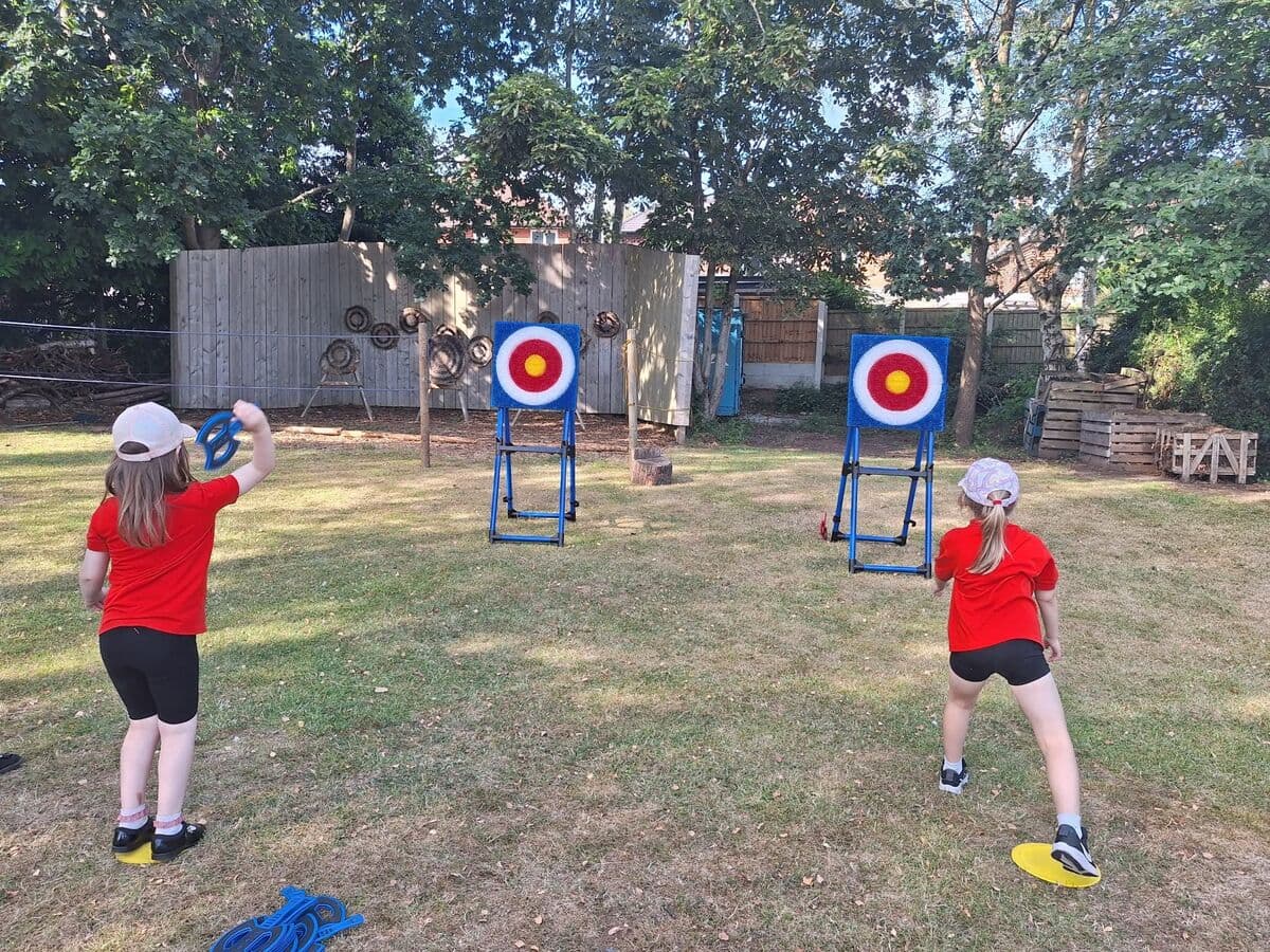 Two Squirrels playing ring toss at outdoor targets on a sunny day