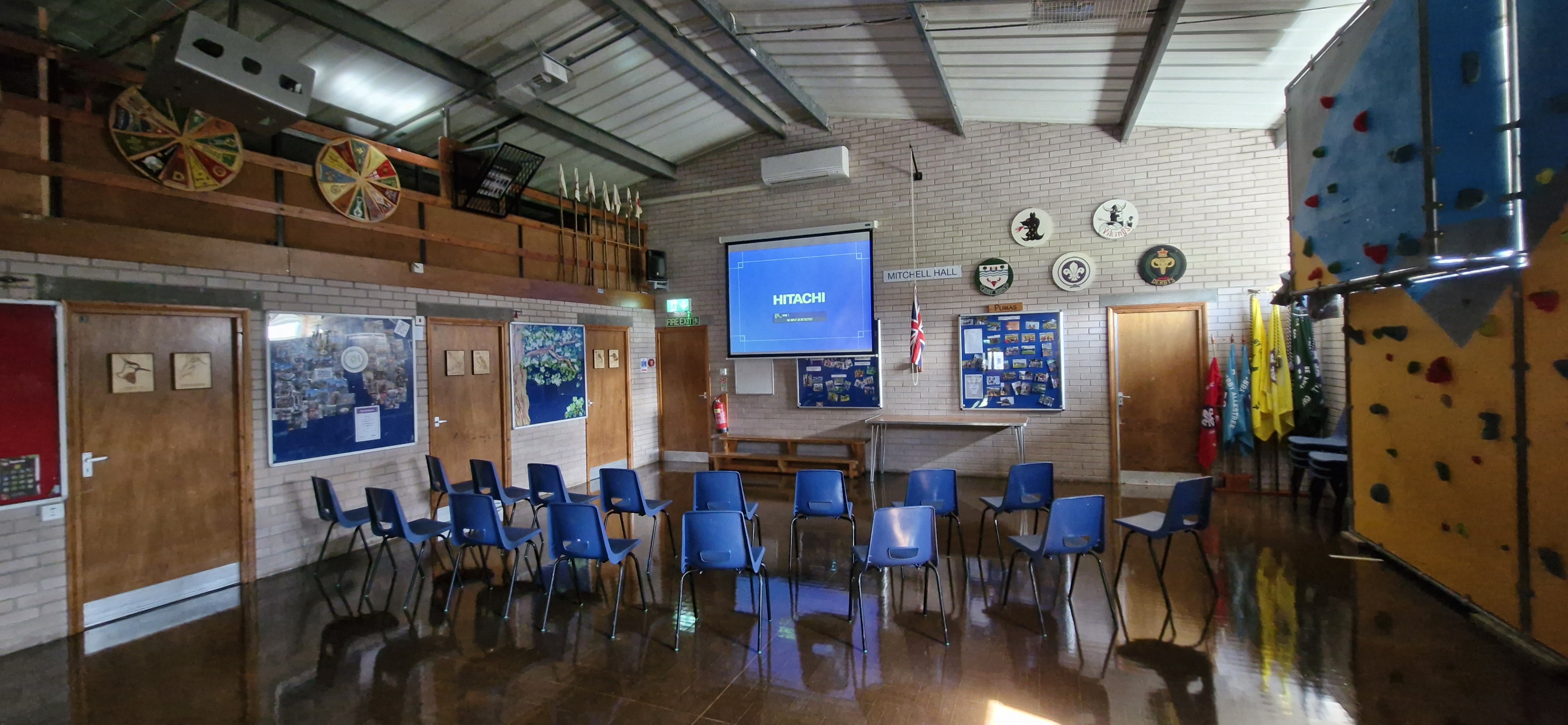 Hall set up in theatre style with chairs facing a projector screen
